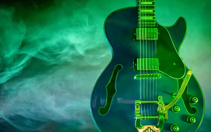 Michael Lander: Close-up of a hollow-body guitar in green smoke