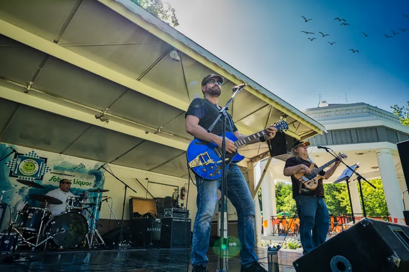 Michael Lander: Live with blue electric guitar, outdoor festival stage